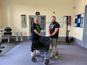 a man and a woman smiling by a wheelchair