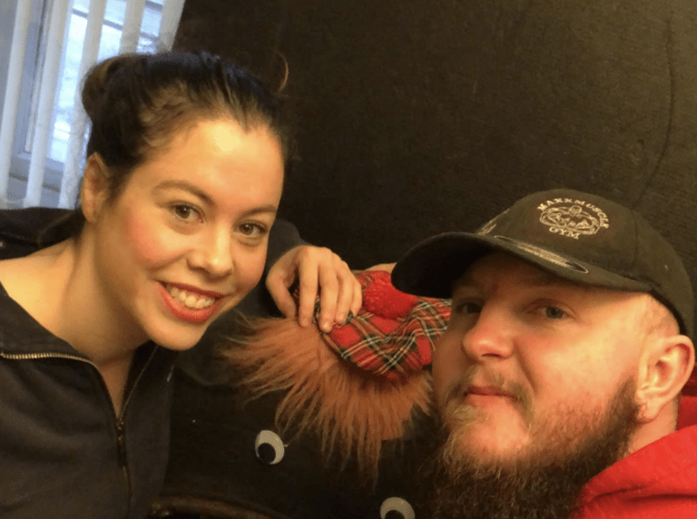 A young woman smiling with a man with a beard