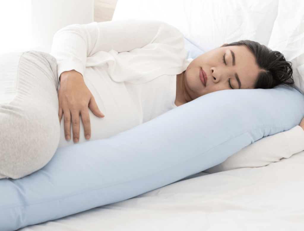 A women with hypermobility sleeping with a U shaped pillow