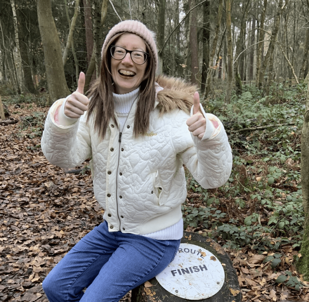 A woman with Ehlers Danlos syndrome siting next to a hiking trail