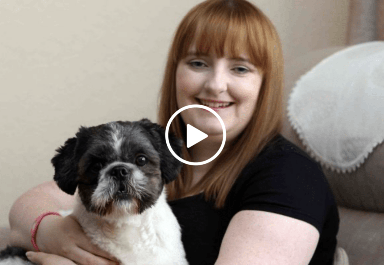 A woman with Red hair holding a black and white dog
