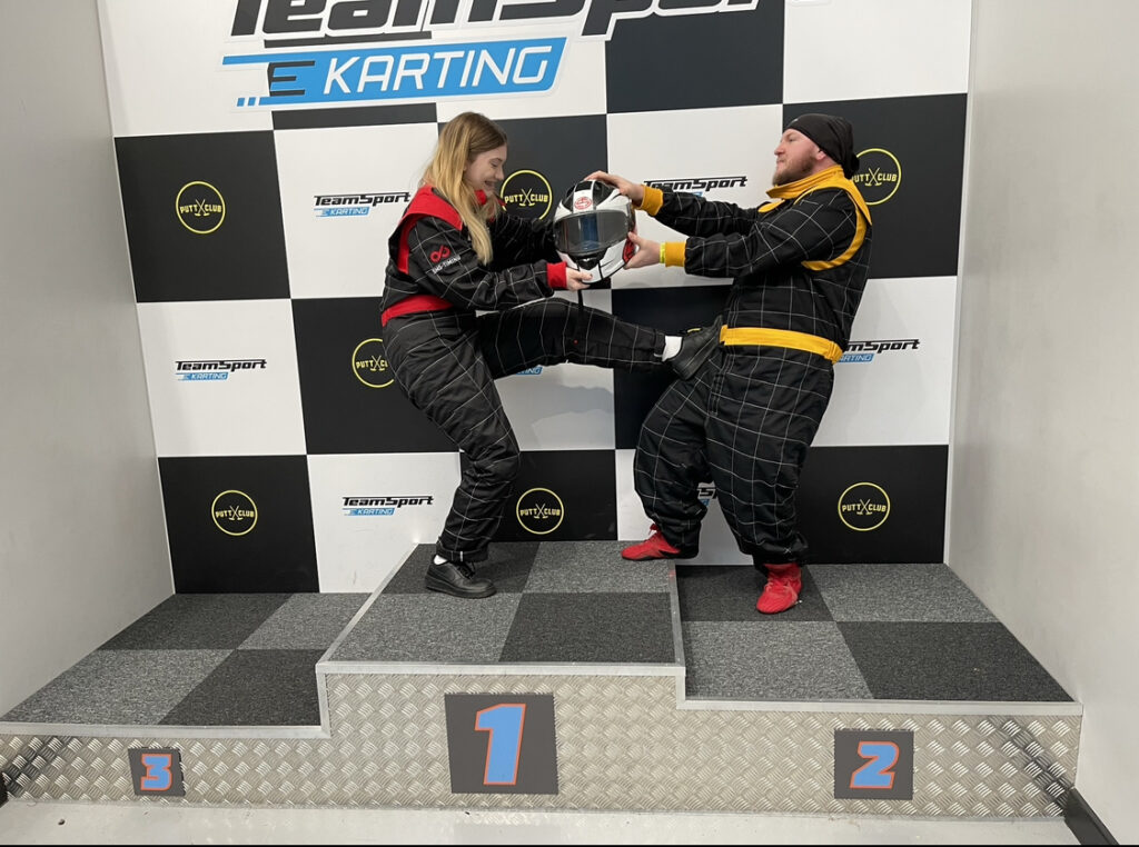 A man and woman holding a go karting trophy