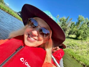 A woman in a Katak wearing a hat and sunglasses smiling