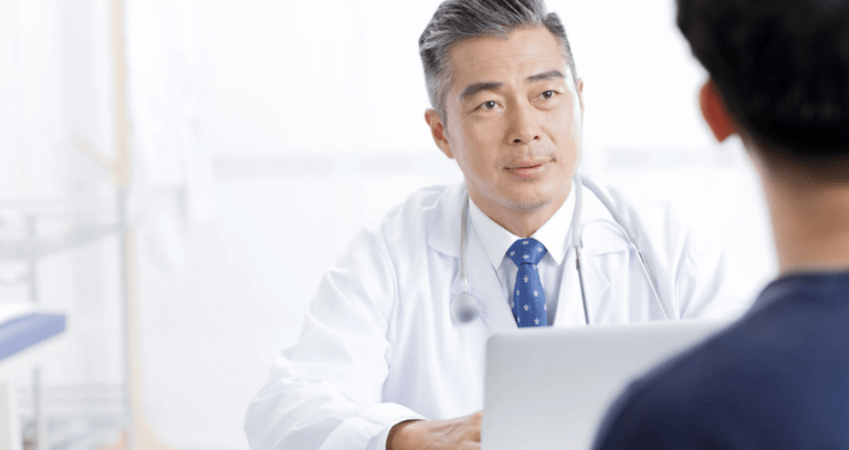 a male doctor talking to a male patient