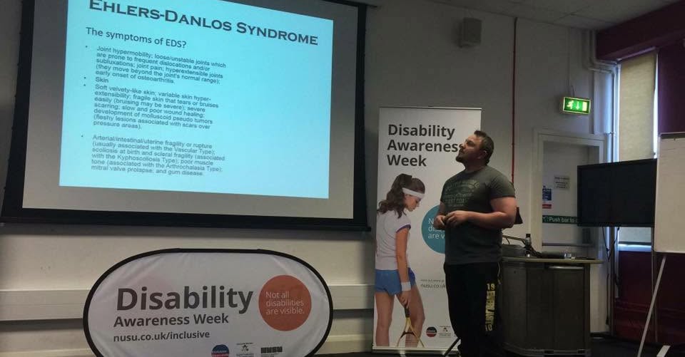 A man presenting in front of a projector screen