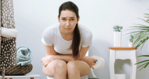 A woman sat constipated on the toilet