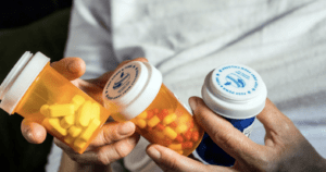A man holding a range of medication